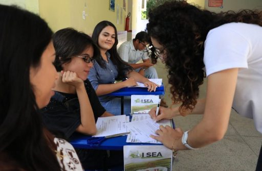 Participantes do evento e uma pessoa da comissão confirmando a presença dos mesmos via assinatura.