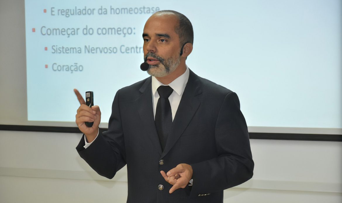 O professor Allan Kardec Duailibe Barros Filho aparece em frente a um quadro branco ministrando aula.