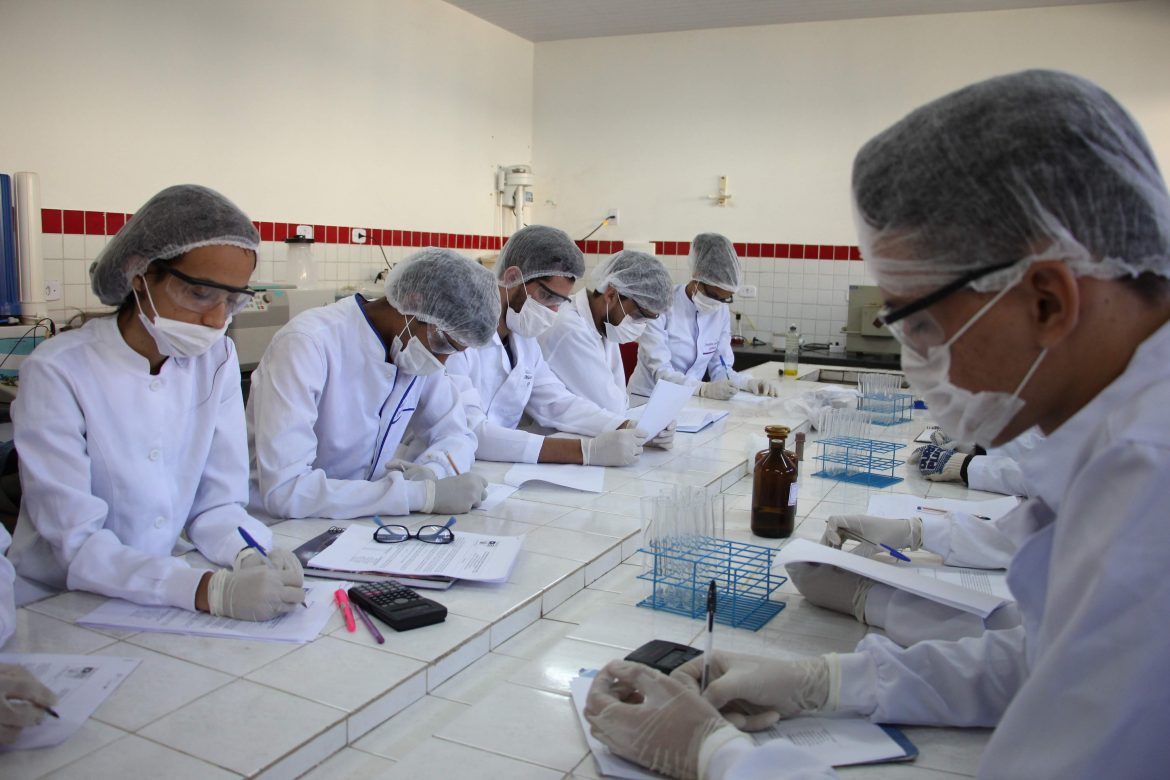 Estudantes em laboratório da UEMASUL realizam procedimentos científicos.