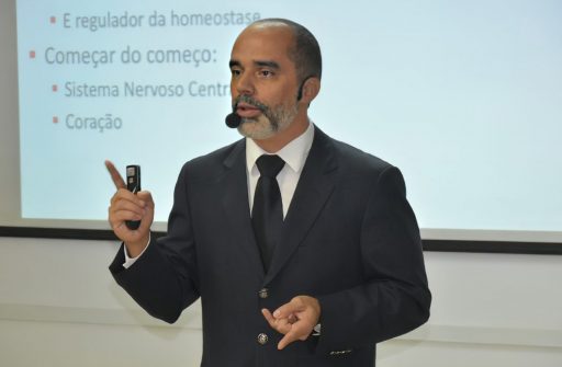 O professor Allan Kardec Duailibe Barros Filho aparece em frente a um quadro branco ministrando aula.